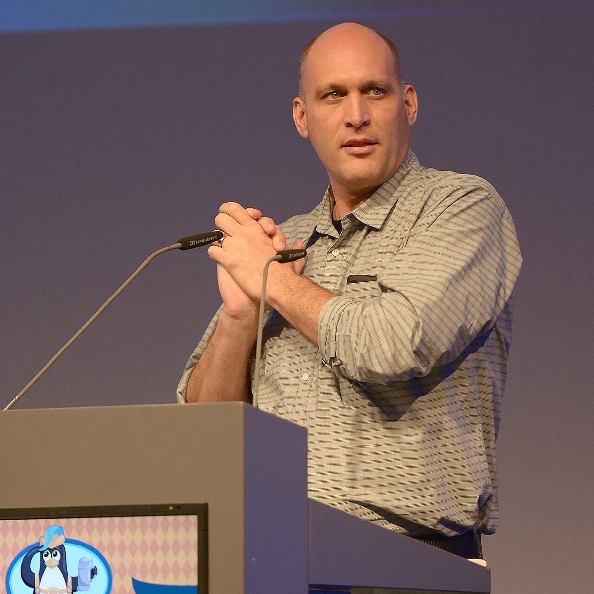 Greg Kroah-Hartman speaking on stage at LinuxCon Europe 2014, holding a microphone