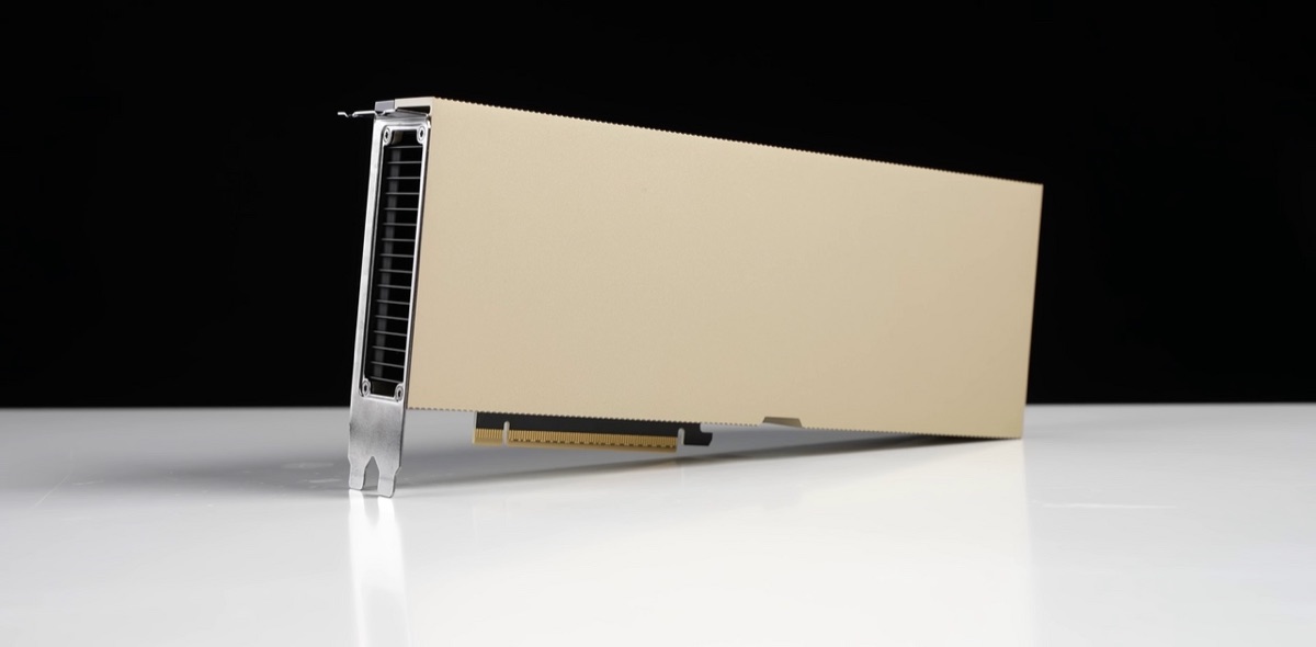 A beige, fanless Nvidia H100 PCIe accelerator card standing on a white surface against a black background