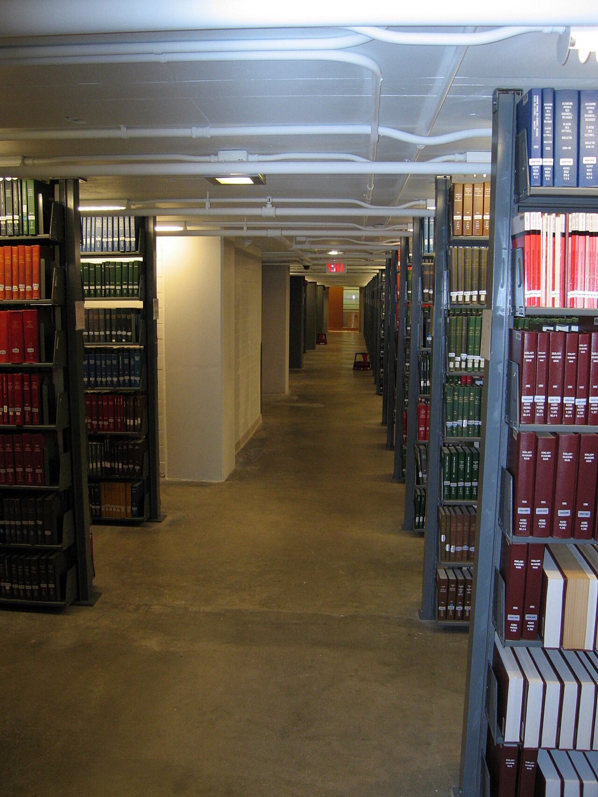 Rows of library shelves filled with bound volumes stretching into the distance