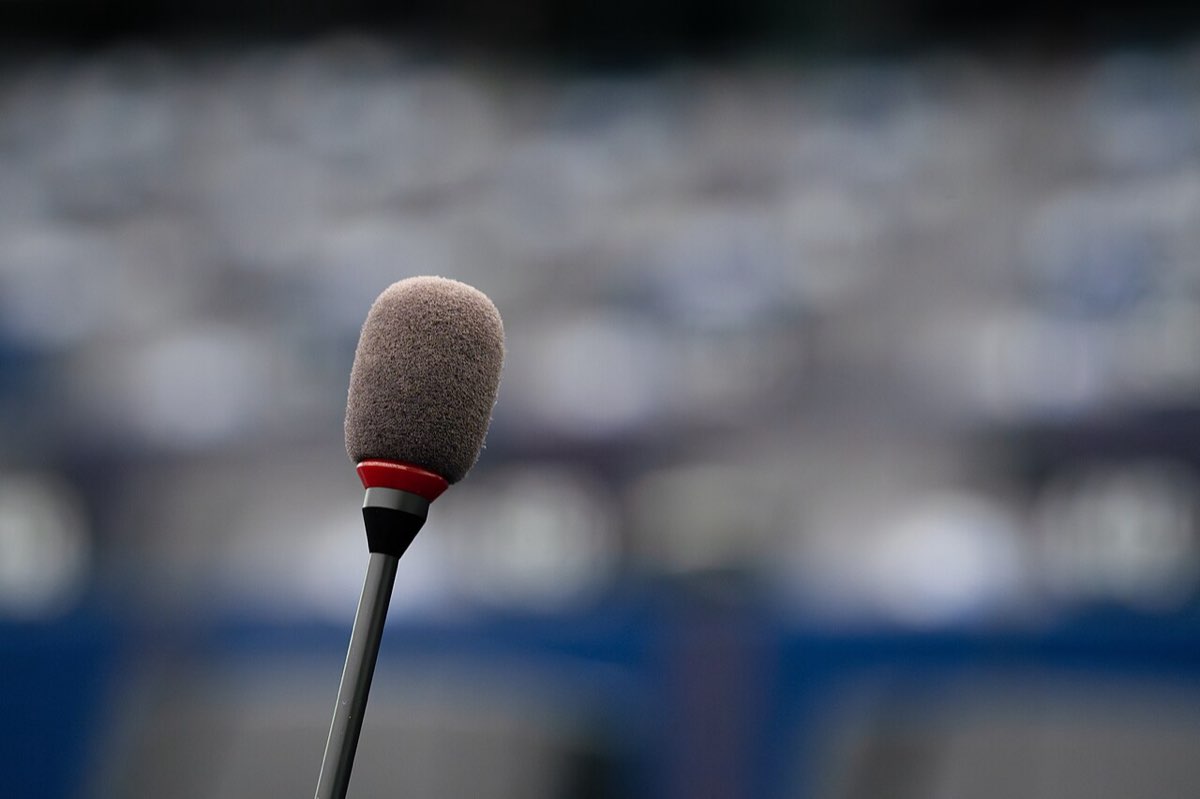 A microphone in the foreground of the European Parliament's chamber in Strasbourg, with rows of seats blurred behind it