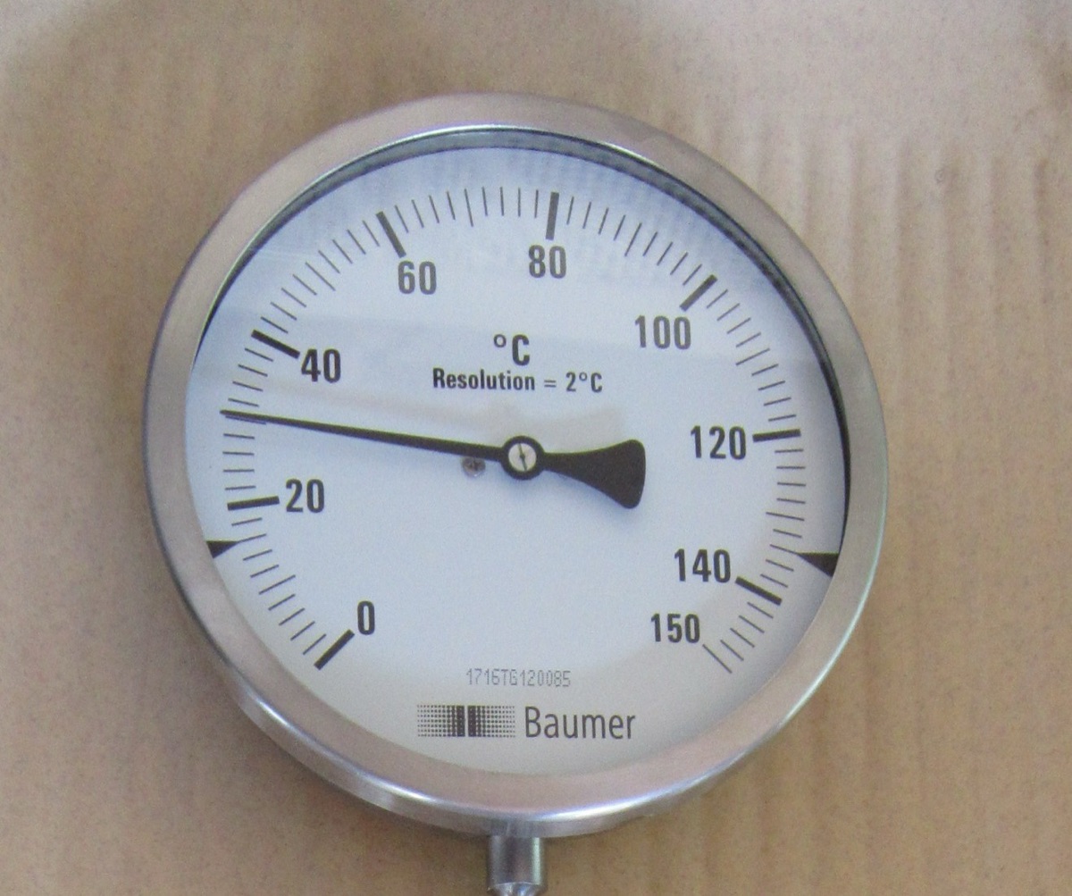 An industrial dial thermometer with a needle pointing near 30 degrees Celsius on a scale from 0 to 150