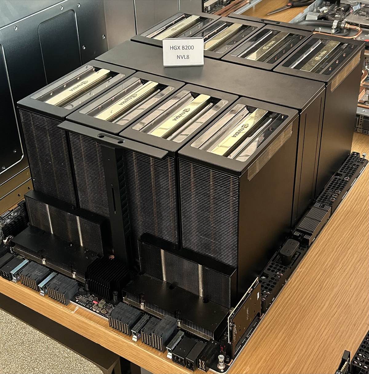 An Nvidia HGX B200 board with eight large GPU heatsinks arranged in two rows on a workbench