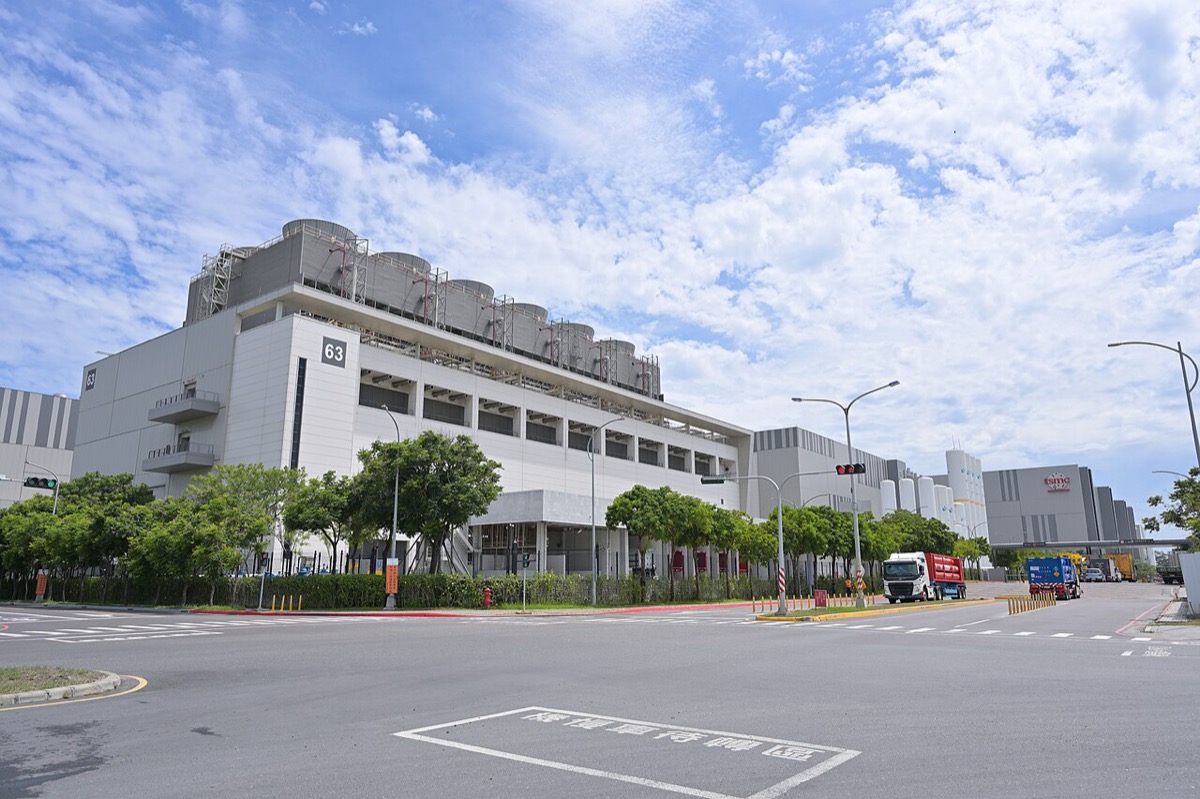 The TSMC Fab 18 complex in the Southern Taiwan Science Park, large white factory buildings under a blue sky