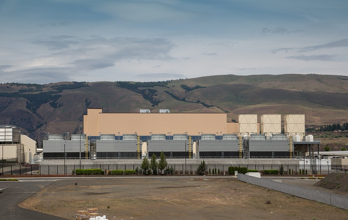A large Google data center in The Dalles, Oregon: long low industrial buildings with cooling towers beside a road