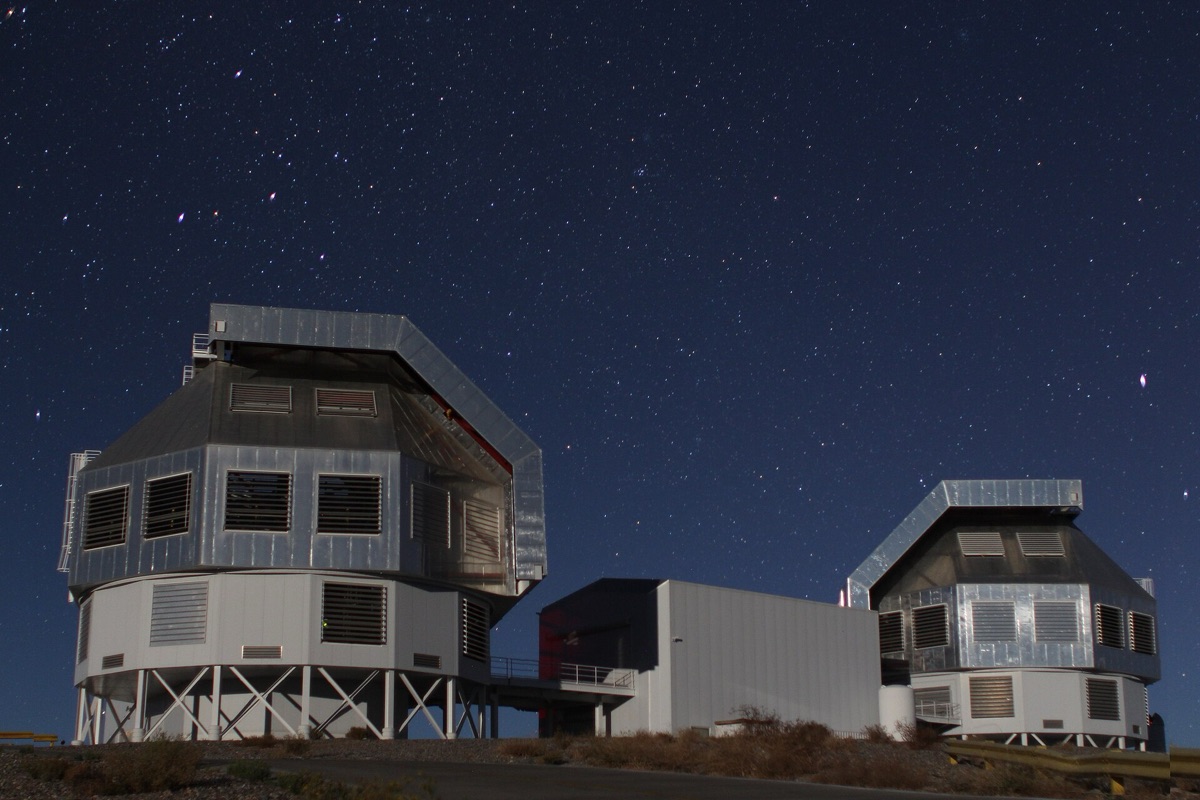 The two Magellan telescope enclosures at Las Campanas Observatory under a starry night sky