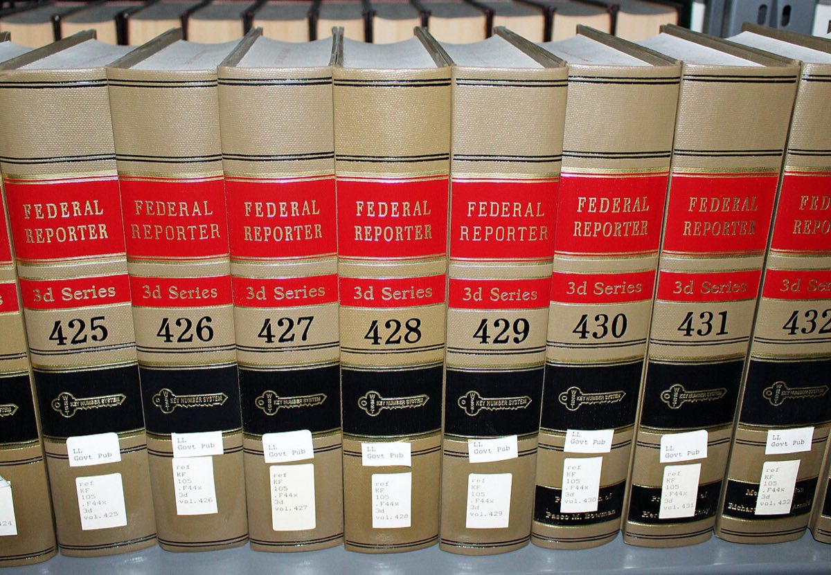 A row of tan law book volumes with red labels reading Federal Reporter 3d Series, numbered 425 to 432, on a library shelf