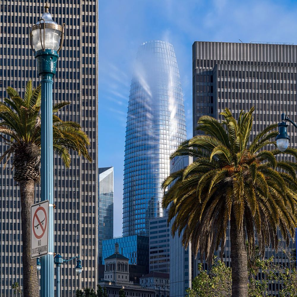 The tapering glass Salesforce Tower in San Francisco partly wrapped in fog in the evening light